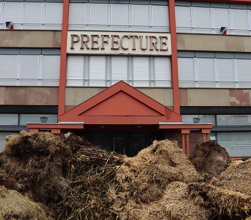 La préfecture d’Epinal s’est vue décorée de fumier, de cannes de maïs souillées par les sangliers et de bottes de foin abîmées par les innondations devant sa porte d’entrée. © Photo Marion FALIBOIS
