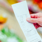 Client d'une grande surface consultant son ticket de caisse. © DR iStock